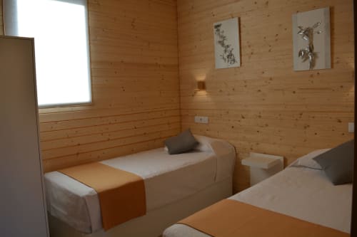 Acogedora habitación de cabaña de madera con dos camas individuales, caminos naranja y arte botánico en Cabañas Compostela