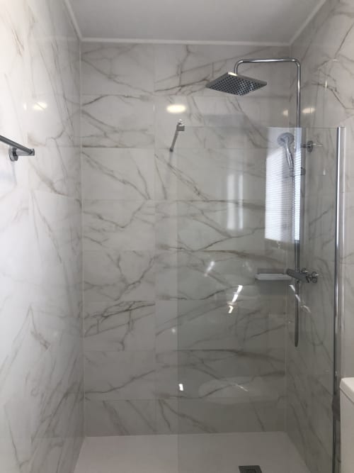 Moderno baño de mármol con ducha de efecto lluvia en Cabañas Compostela, Santiago de Compostela