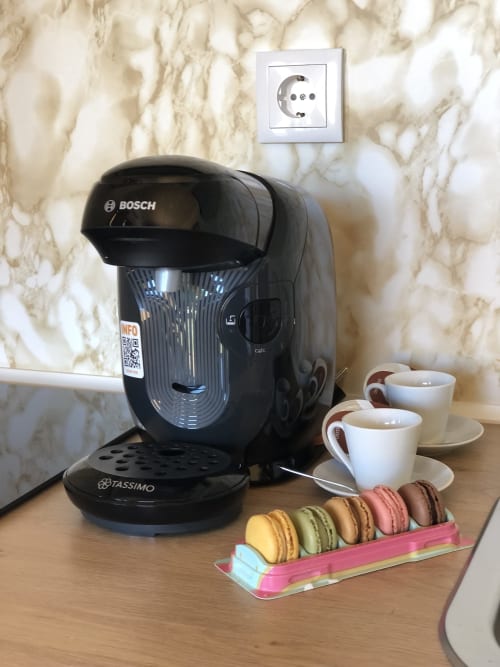 Cafetera Bosch Tassimo con macarons y tazas en apartamento Cabañas Compostela, Santiago de Compostela