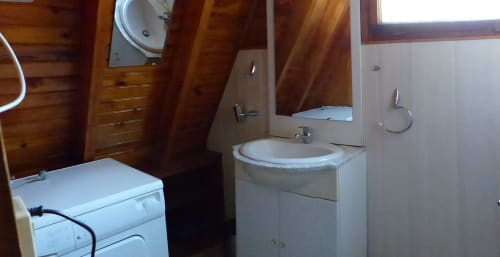 Salle de bains commune du Chalet Classique aux Chalets Cocody, Jausiers, avec lavabo blanc, toilettes et douche