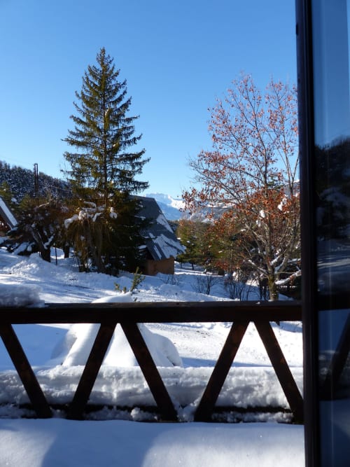 Balcon enneigé aux Chalets Cocody avec vue sur les montagnes, sapins et paysage alpin à Jausiers