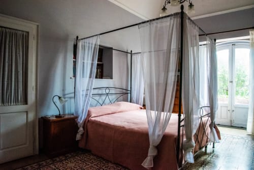 Elegante letto a baldacchino con tende leggere in luminosa camera con vista giardino di B&B Valle Allegra
