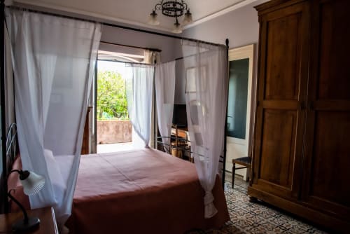 Camera elegante con letto a baldacchino a quattro colonne e tende bianche trasparenti presso B&B Valle Allegra a Gravina di Catania, Sicilia