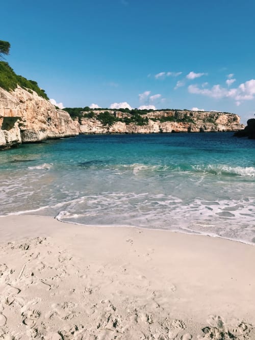Türkisfarbener Mittelmeersstrand mit Kalksteinklippen beim Hotel Sa Roqueta, Can Picafort