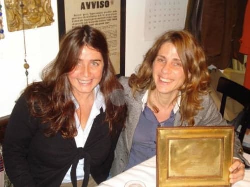 Due donne sorridenti all'hotel Ca Corrigiane di Venezia che tengono un premio incorniciato