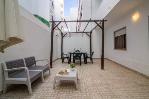 Pátio das Residências Armação com pérgola, área de estar e mesa de jantar em Armação de Pêra