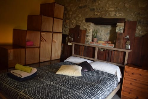 Acogedora habitación en el hostal La Calma De Bellver con muebles de madera, ropa de cama estampada y vistas a las montañas en Bellver de la