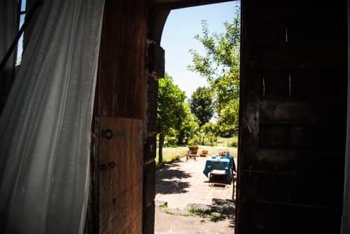 Cancellate in legno aperte di B&B Valle Allegra con cortile, sedute esterne e alberi a Gravina di Catania, Sicilia