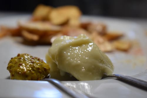 Postre gourmet presentado en plato con pastel especiado y crema blanca en el albergue La Calma De Bellver, Bellver de la Cerdanya