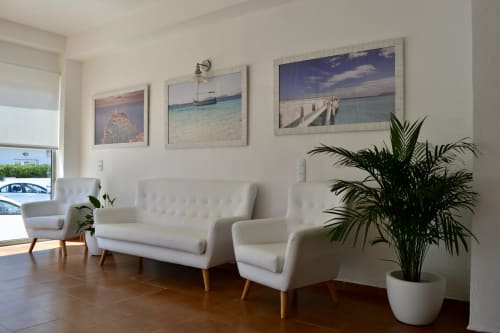 Hotel Sa Roqueta lobby with white modern furniture, coastal artwork, and green plants in Can Picafort