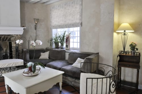 Élégant séjour de la chambre d'hôtes Aux Fleurs de Cerises au Plessis Luzarches avec canapé sombre, table basse blanche, cheminée et