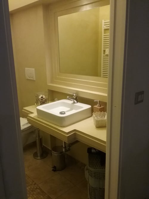 Bagno moderno nell'appartamento Tommaso di Orso Luxury Apartments Roma con lavabo vessel e specchio illuminato