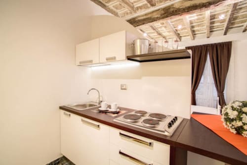 Cucina moderna nell'appartamento Tommaso di Orso Luxury Apartments Roma, con mobili bianchi e cucina in acciaio inox