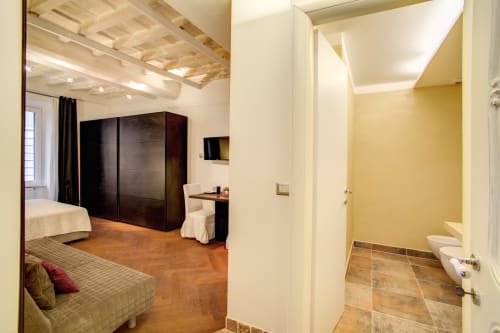 Bernini apartment at Orso Luxury Apartments, Roma - bedroom with en-suite bathroom, modern furnishings and wooden flooring