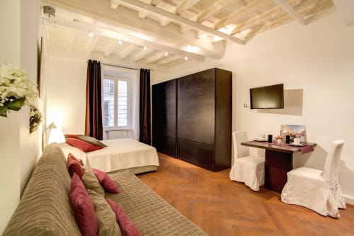 Bernini apartment at Orso Luxury Apartments in Roma with wooden beams, city view, and modern furnishings