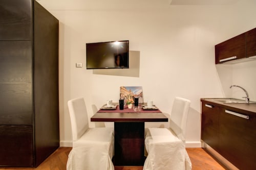 Bernini apartment dining area at Orso Luxury Apartments Rome with kitchen, TV, and city view
