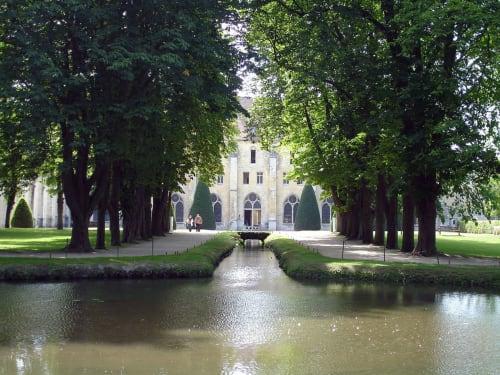 Église historique et canal bordé d'arbres à l'Aux Fleurs de Cerises B&B au Plessis Luzarches, France