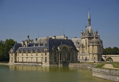 Château de Chantilly se reflétant dans l'eau près du gîte Aux Fleurs de Cerises, Le Plessis Luzarches, France