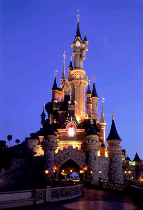 Le château de Cendrillon illuminé au crépuscule sous un ciel bleu twilight