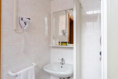 Moderno bagno di Alloggio Le Casette, Verona con lavabo bianco, specchio, asciugacapelli e doccia