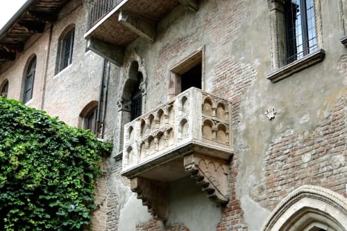 Medieval balcony on historic Verona building at Alloggio Le Casette with ivy and arched windows