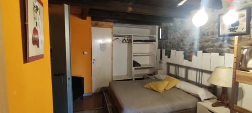 Habitación de hostal en La Calma De Bellver con cama, detalles amarillos, armario y acceso a balcón con vistas al paisaje