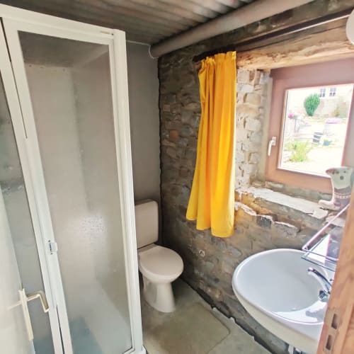 Moderne badkamer met douche, toilet, wastafel en geel douchegordijn in studio La Ferme De Werpin, Hotton