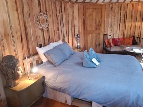 Cozy bedroom in La Yourte de Bouddha cottage at Les Refuges Du Chalet, Jalhay, with wooden walls and blue bedding