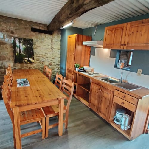 Spacious kitchen and dining area in La Ferme De Werpin apartment with wooden furniture and modern appliances