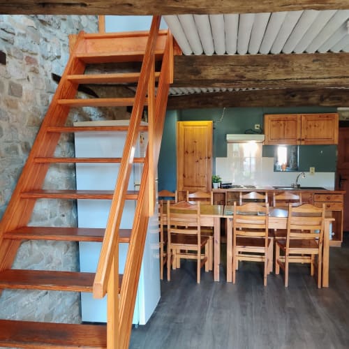 Rustic wooden staircase with dining area and kitchen in La Ferme De Werpin apartment, Hotton