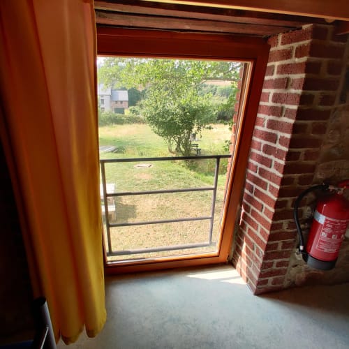 Garden view through open door with terrace at La Ferme De Werpin B&B in Hotton, Belgium