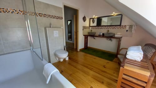 Salle de bain spacieuse à La Maison De Fleurat avec double vasque, baignoire, douche et parquet
