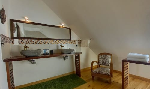 Salle de bains luxueuse à La Maison De Fleurat avec vasques en pierre, miroir décoratif et mobilier en bois à Domeyrot, France