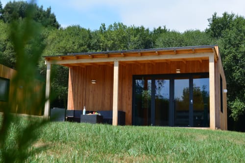 Moderna cabaña de madera Cabana Sarela en Cabañas Compostela con terraza, vistas al jardín y puertas de cristal con marcos negros
