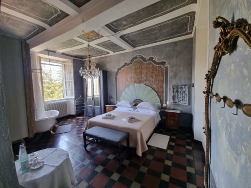 Elegante camera da letto presso B&B La Corte Ovada a Ovada, Italia, con letto a baldacchino, lampadario in cristallo e arredi raffinati.