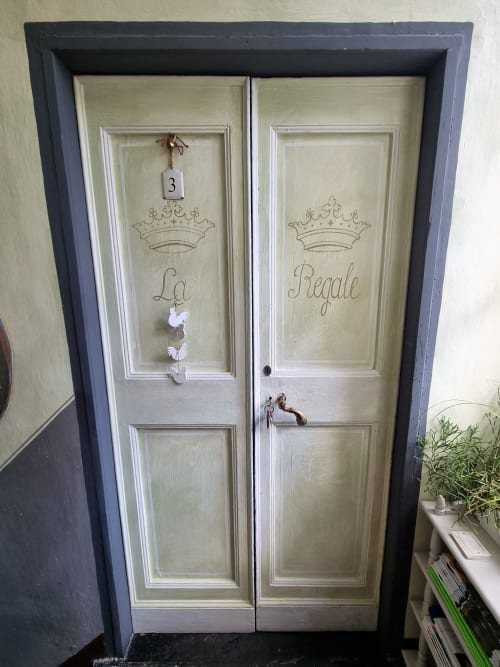 Eleganti porte doppie color crema con decorazioni a corona presso B&B La Corte Ovada a Ovada, Italia