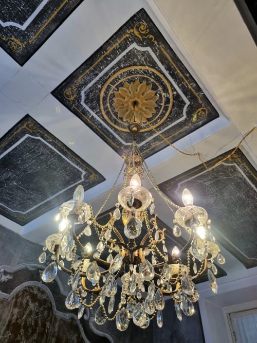 Lustre in cristallo ornamentale sospeso al pannello del soffitto decorato in nero e oro della B&B La Corte Ovada, Ovada