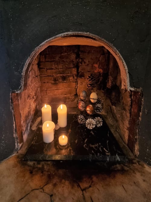Nicchia in mattone rustico con candele accese e pigne a B&B La Corte Ovada, Ovada
