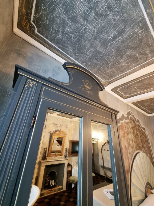 Elegante ingresso con porta incorniciata in blu presso il B&B La Corte di Ovada, con camino e arredi d'epoca