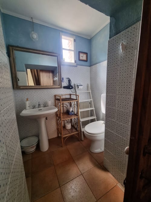 Bagno spazioso in B&B La Corte Ovada con doppio lavabo, wc, doccia e scaffalatura in legno