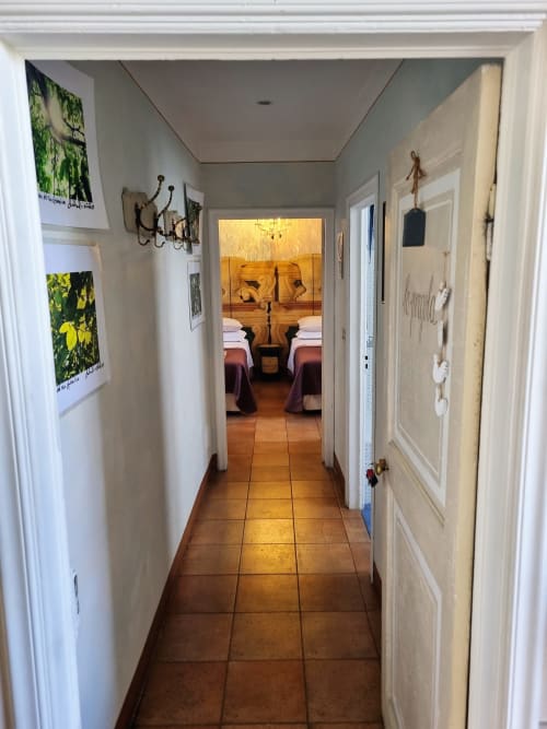 Corridoio della B&B La Corte Ovada che conduce alla camera con pavimenti in cotto e porte bianche, Ovada