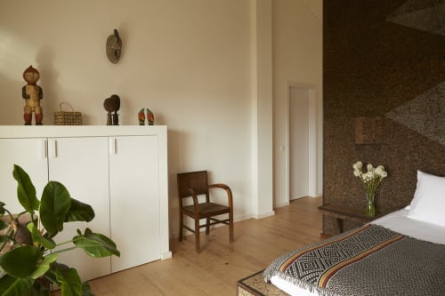 Cortiça room at Cavalo de Madeira B&B in Arelho with bed, white cabinet, wooden chair, and cork accent wall
