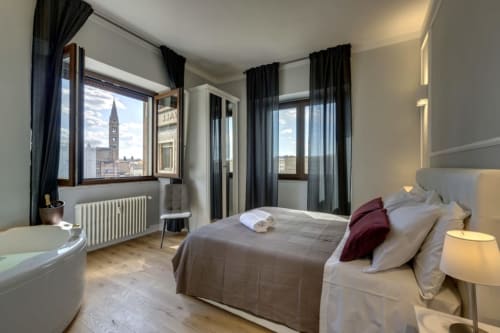 Modern bedroom at Sleep tight Florence BnB with city views, queen bed, and Florence skyline visible through windows