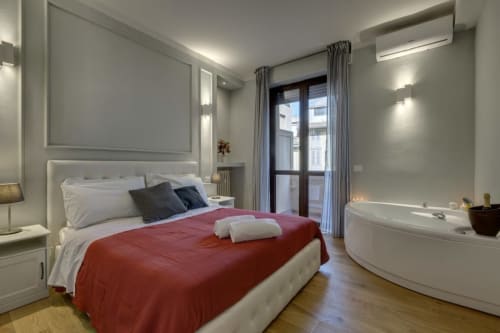 Modern bedroom with red bedding at Sleep tight Florence B&B, featuring en-suite bathtub and balcony in Firenze