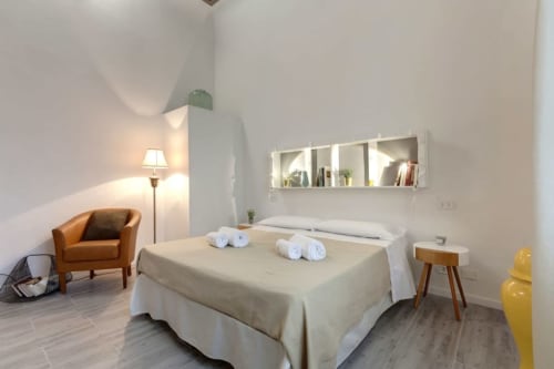 Modern bedroom at Sleep tight Florence B&B in Firenze with bed, orange chair, and minimalist décor