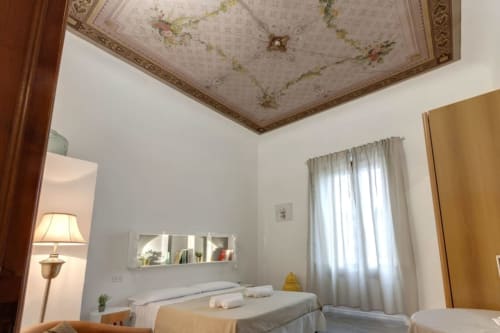 Elegant bedroom at Sleep tight Florence B&B in Firenze with ornate ceiling, two beds, and natural light