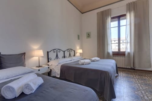 Spacious twin bedroom at Sleep tight Florence B&B in Firenze with elegant iron beds, terracotta flooring, and city views