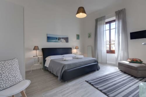 Modern bedroom at Sleep Tight Florence with double bed, white walls, and balcony views of Firenze