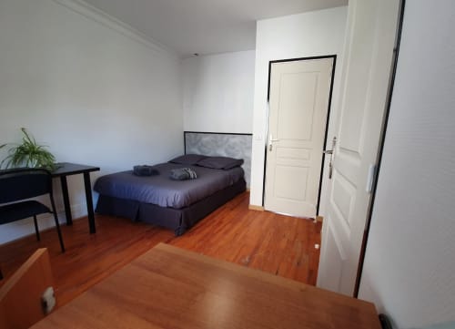 Chambre moderne de la suite NancyRoom avec lit queen-size, parquet, portes blanches et décoration minimaliste à Vandœuvre-lès-Nancy