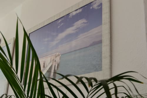 Framed seascape with wooden pier at Hotel Sa Roqueta, Can Picafort, with green plant foliage in foreground
